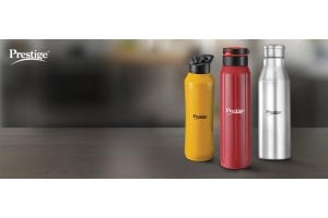Prestige water bottles in yellow, red, and silver on a wooden surface