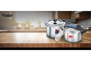 Prestige stainless steel pressure cookers displayed on a kitchen countertop, featuring the Flip-On model and classic design