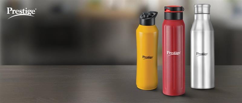 Prestige water bottles in yellow, red, and silver on a wooden surface
