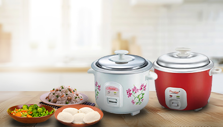 Two Prestige Electric Rice Cookers with prepared food on a kitchen table