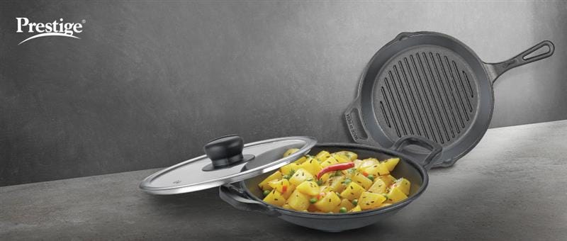 Prestige cast iron cookware featuring a skillet with lid and grill pan, displaying cooked vegetables, showcasing the versatility of cast iron cookware.