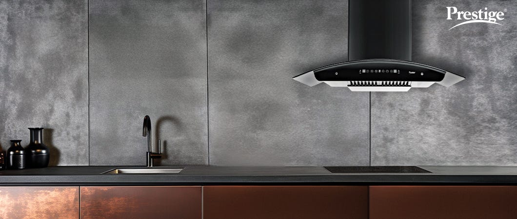 Prestige black kitchen chimney installed in a modern kitchen with dark grey walls and brown cabinets, enhancing ventilation and smoke-free cooking.